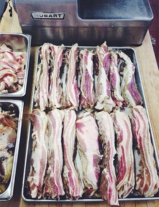 Trays of house-cured pancetta laid out in the kitchen